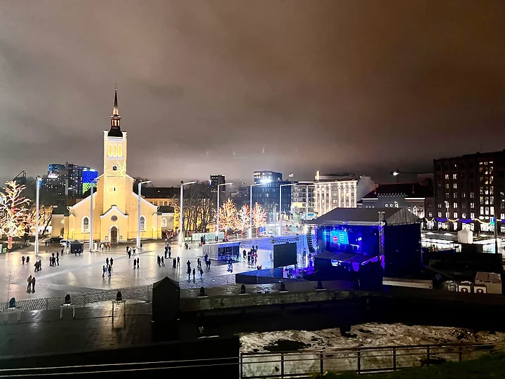 Vibrant New Year's Eve celebration in the picturesque streets of Tallinn, Estonia, with fireworks lighting up the night sky.